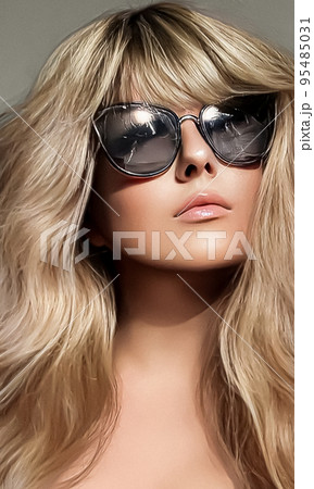 Luxury fashion, blonde hairstyle and accessories, beauty face portrait of a woman with long blond hair, wearing chic sunglasses, glamour style close-up Luxury fashion, blonde hairstyle and accessories, beauty face portrait of a woman with long blond hair, wearing chic sunglasses, glamour style close-up 95485031