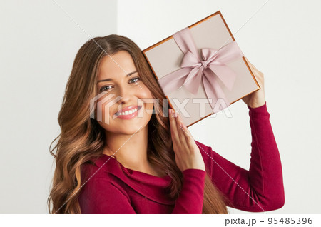 Holiday present for birthday, baby shower, wedding or luxury beauty box subscription delivery, happy woman holding a wrapped pink gift on white background Holiday present for birthday, baby shower, wedding or luxury beauty box subscription delivery, happy woman holding a wrapped pink gift on white background 95485396
