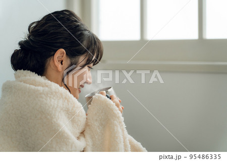 秋冬の寒い日にホットドリンクを飲むアジア人女性（白湯・お湯・甘酒） 95486335