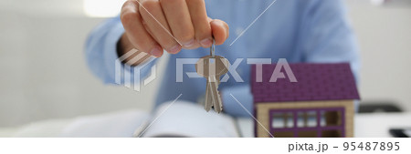 Male worker in suit give key to unlock new miniature house, buy new accommodation Male worker in suit give key to unlock new miniature house, buy new accommodation 95487895