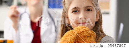 Cute smiling child at pediatrician, kid hug teddy bear favourite toy 95487897