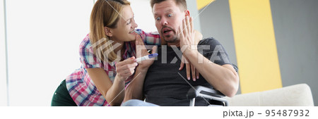 Surprised husband got news about wife pregnancy, middle aged man in wheelchair 95487932
