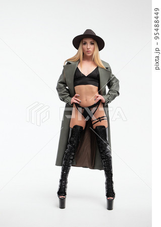 Sensual young lady in lingerie and coat looking at camera in studio 95488449