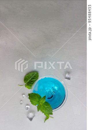 Top view of blue cocktail in martini glass with ice cubes and mint Top view of blue cocktail in martini glass with ice cubes and mint 95488455