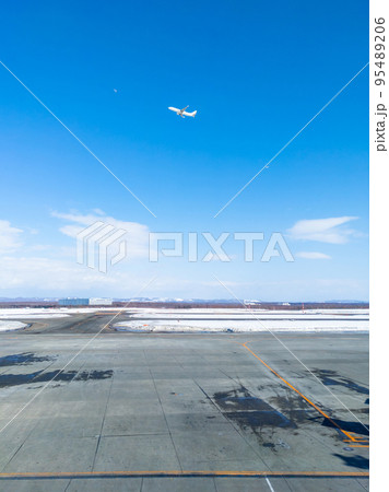 積雪の空港を発つ飛行機を見送る (北海道、新千歳空港) 95489206