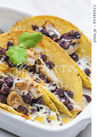 tacos filled with grilled chicken meat, red beans and grated cheese tacos filled with grilled chicken meat, red beans and grated cheese 95489421