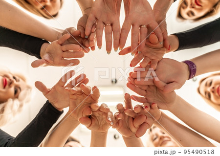 Team of people holding hands. Group of happy young women holding hands. Bottom view, low angle shot of human hands. Friendship and unity concept Team of people holding hands. Group of happy young women holding hands. Bottom view, low angle shot of human hands. Friendship and unity concept 95490518