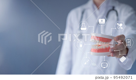 Dental care concept. Dentist with plastic teeth model and health icon. Oral health and dental hygienists. Medical and healthcare technology. 95492071