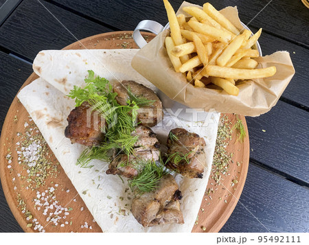 Street fast food, French fries, pita bread and pieces of grilled meat. Studio Photo Street fast food, French fries, pita bread and pieces of grilled meat. Studio Photo 95492111