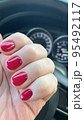 Short nails with colored nail polish on woman's hand. Stuio Photo 95492117