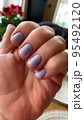 Short nails with colored nail polish on woman's hand. Stuio Photo 95492120