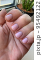 Short nails with colored nail polish on woman's hand. Stuio Photo 95492122