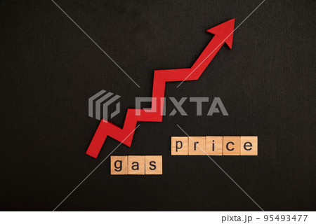 Word gas price assembled from wooden letters game and red arrow on black school chalkboard 95493477