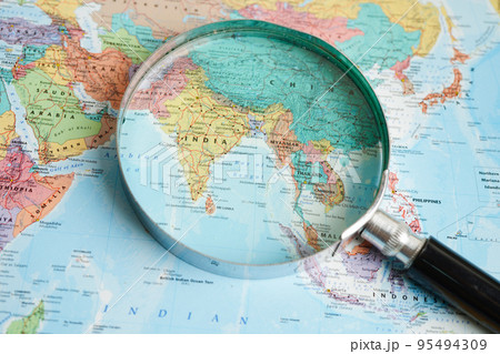 Bangkok, Thailand - May 15, 2022 Magnifying glass on world map. Bangkok, Thailand - May 15, 2022 Magnifying glass on world map. 95494309