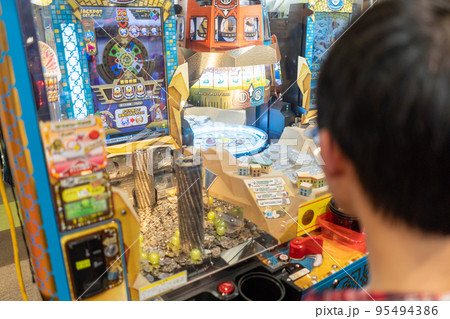 ゲームセンターでメダルゲームをする少年 95494386