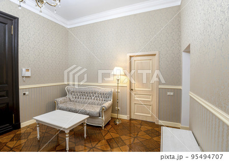 Hallway in a house with a wooden floor and doors to other rooms 95494707