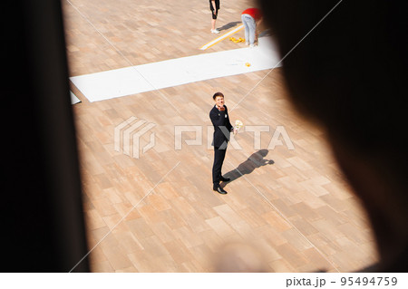 the groom with a bouquet of flowers is waiting for the bride on the window. 95494759