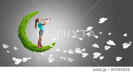Concept of careless happy childhood with girl on green moon 95494829