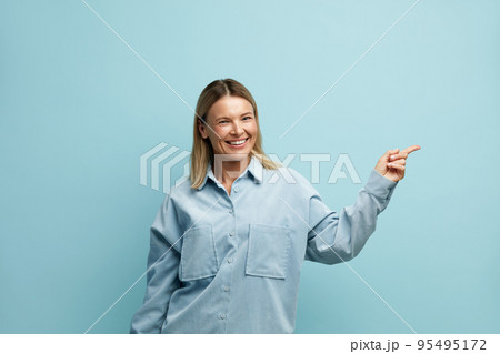 Happy Woman Pointing Aside. Amused Girl Points Away at the Empty Copy Space Happy Woman Pointing Aside. Amused Girl Points Away at the Empty Copy Space 95495172