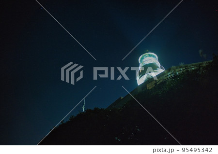 夜空に浮かび上がるライトアップされた白い灯台 95495342