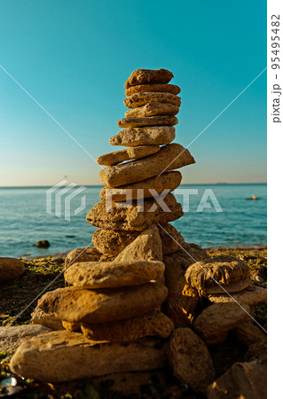Laying beach stones balancing rocks on a sand seashore 95495482