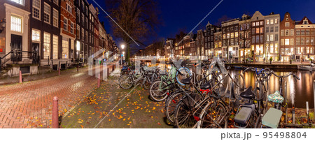 Beautiful old houses on the city waterfront of Amsterdam at sunset. 95498804