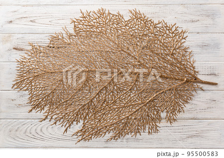 Top view of golden leaf shaped tablecloth for food on cement background. Empty space for your design. 95500583