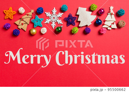 Merry Christmas text. Top view of holiday decorations and toys on red background. Christmas ornament concept with empty space for your design Merry Christmas text. Top view of holiday decorations and toys on red background. Christmas ornament concept with empty space for your design 95500662