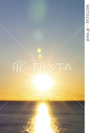 Blurred background. Sun shining in blue sky during sunset dawn. Sunrise dawning sundown. Sunny path, sunny walkway on surface of sea waves. Sunlight Sunbeams Sea landscape Natural blurry bokeh texture 95501206