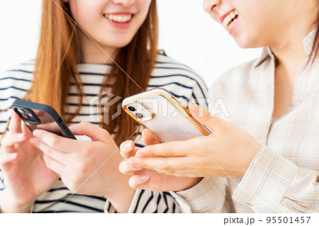 スマホを見て笑う若い女性二人 95501457