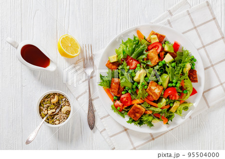 tofu salad with greens and vegetables on plate tofu salad with greens and vegetables on plate 95504000