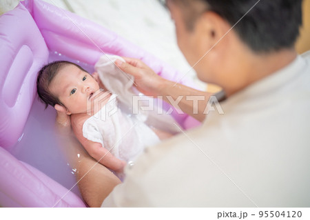 沐浴する赤ちゃん(新生児・パパ・父・子供・子ども・0歳・育児・子育て・お風呂・入浴) 沐浴する赤ちゃん(新生児・パパ・父・子供・子ども・0歳・育児・子育て・お風呂・入浴) 95504120