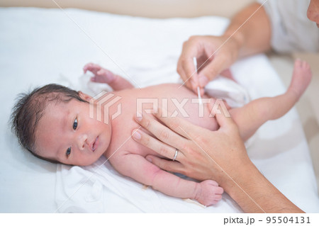 沐浴後おへそを掃除される赤ちゃん(新生児・パパ・父・子供・子ども・0歳・育児・子育て・お風呂・入浴) 沐浴後おへそを掃除される赤ちゃん(新生児・パパ・父・子供・子ども・0歳・育児・子育て・お風呂・入浴) 95504131