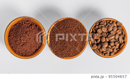 three small saucers with coffee beans, ground coffee and cocoa on a white background. three small saucers with coffee beans, ground coffee and cocoa on a white background. 95504657