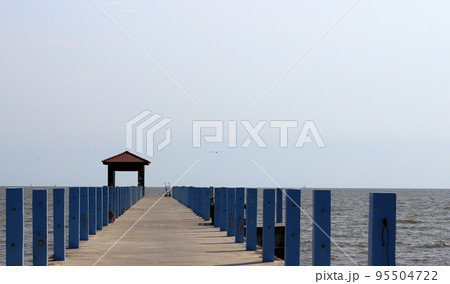 Perspective view of Pier at the sea, jetty and sea in sun light. Perspective view of Pier at the sea, jetty and sea in sun light. 95504722