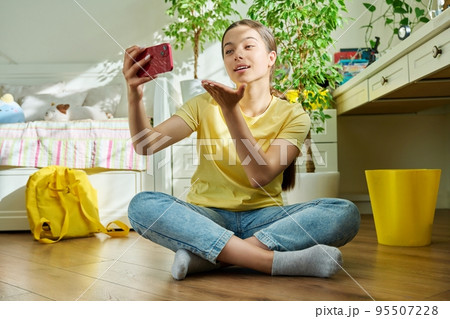 Teenage girl using smartphone for video call, room at home 95507228