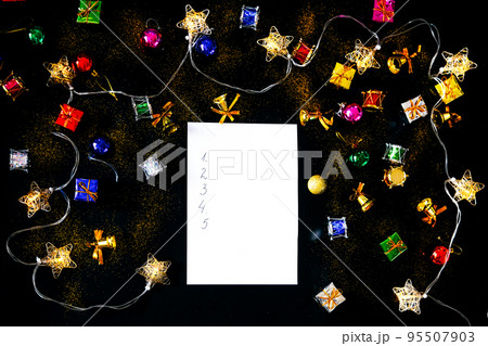 Blank sheet of paper and Christmas decorations. List of goals. 95507903