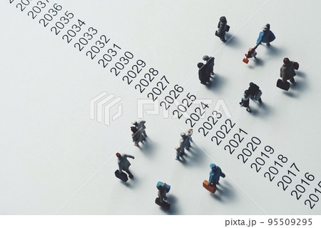西暦の横を歩くミニチュアの人々 95509295