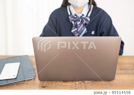 パソコンとマスク姿の女学生 95514556