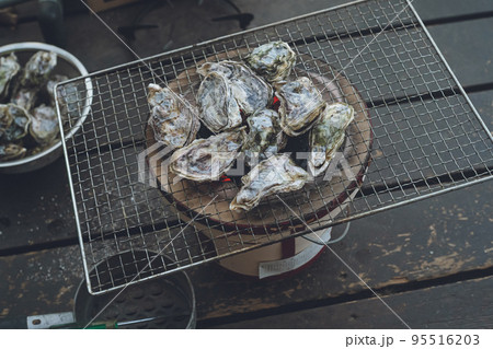 殻付き生牡蠣を木炭を入れた七輪しちりんで網焼きバーベキュー 95516203