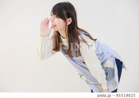 遠くにいる人を呼びかけるエプロンを付けた女性保育士 遠くにいる人を呼びかけるエプロンを付けた女性保育士 95519025