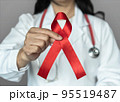 World aids day and national HIV AIDS and ageing awareness month in December with red ribbon on medical or surgical doctor's hand 95519487