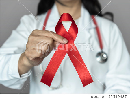 World aids day and national HIV AIDS and ageing awareness month in December with red ribbon on medical or surgical doctor's hand 95519487