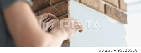 Professional builder put bricks on wall in apartment, handyman work on new project 95520558