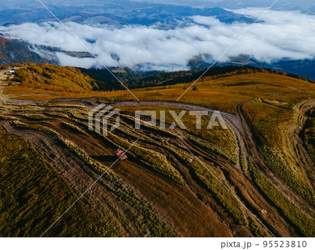 aerial view of suv off road travel climbing up by mountain hill 95523810