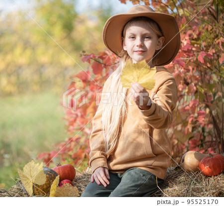 Girl in the hay with pumpkins 95525170