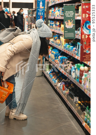 woman in winter outfit do groceries shopping 95525333