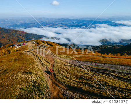 aerial view of suv off road travel climbing up by mountain hill 95525377