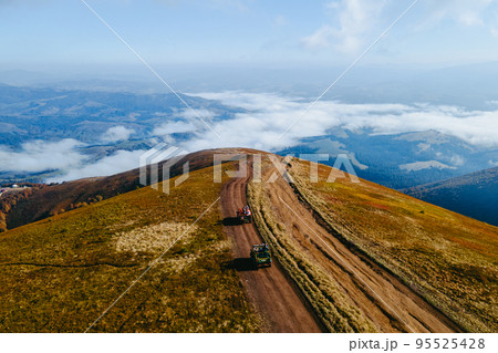 aerial view of suv off road travel climbing up by mountain hill aerial view of suv off road travel climbing up by mountain hill 95525428