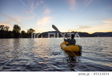 Adventurous Woman Kayaking on an Inflatable Kayak in the Pacific Ocean. Sunset Sky Adventurous Woman Kayaking on an Inflatable Kayak in the Pacific Ocean. Sunset Sky 95532654